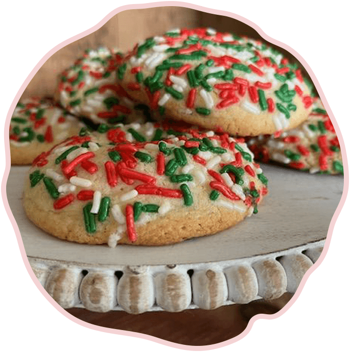 Christmas cookies with sprinkles on a white plate.